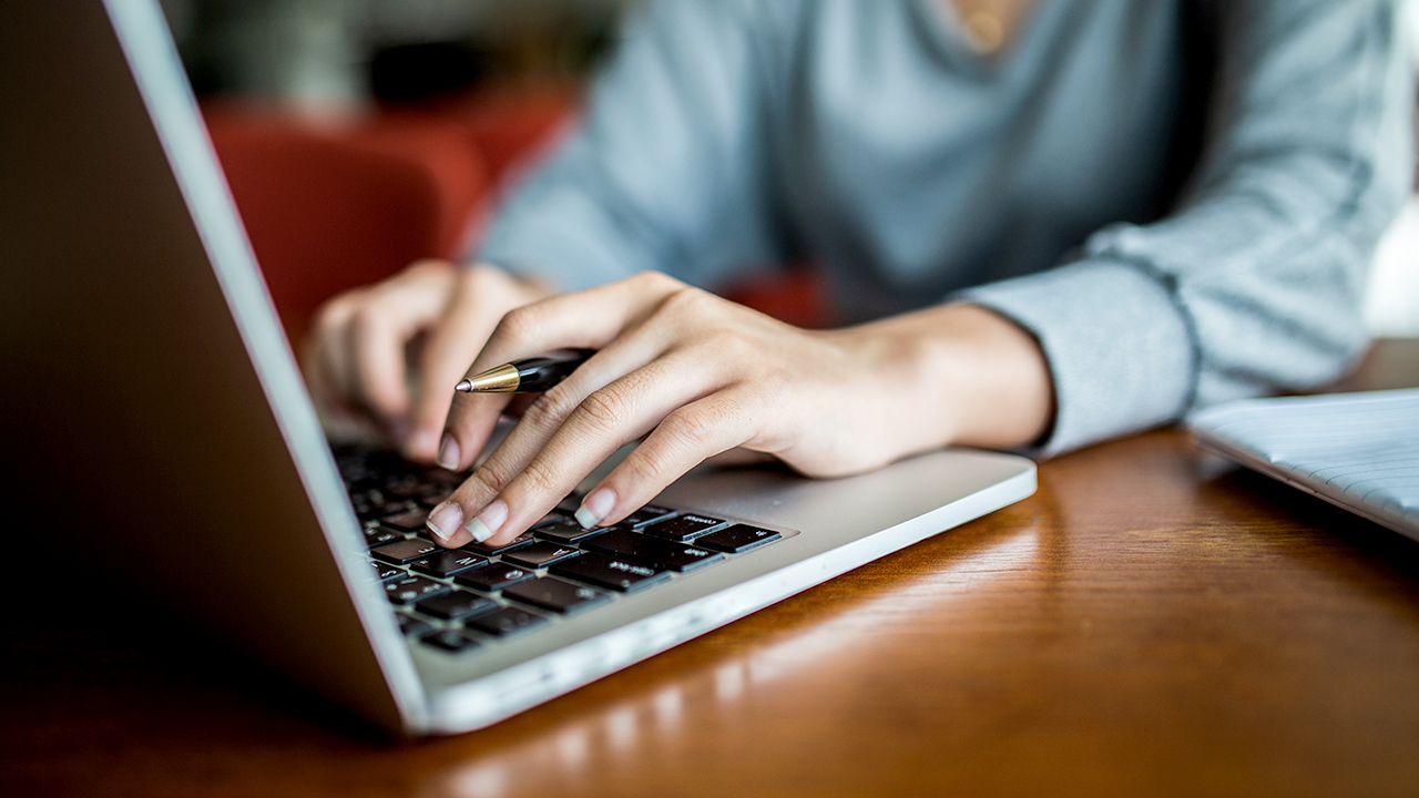 Person searching for information online using a laptop